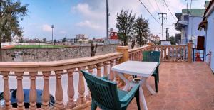 eine Terrasse mit Stühlen und einem Tisch auf dem Balkon in der Unterkunft TARLAS ROOMS in Mytilini