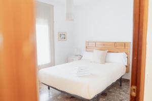 1 dormitorio con cama blanca y ventana en Cal Miquel, en La Pobla de Segur