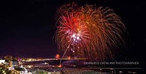 una pantalla de fuegos artificiales por la noche con una ciudad en el fondo en Hotel Flaminio en Cattolica