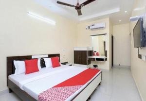 a bedroom with a red and white bed and a tv at Hotel Broadway By WB Inn in Amritsar