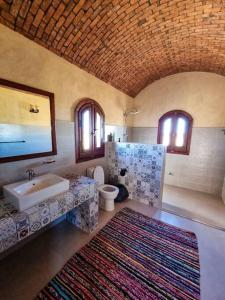 a bathroom with a sink and a toilet at A Home with a Dome in ‘Izbat Ţanāţī