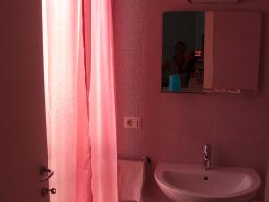 a bathroom with a pink shower curtain and a sink at Hotel Flaminio in Cattolica