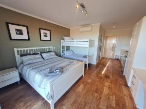 a bedroom with a white bed and a wooden floor at Cue Motel in Cue