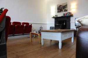 a living room with a coffee table and red chairs at Medieval roots and Harry Potter TownHouse - Hiking near Ludlow in Leominster