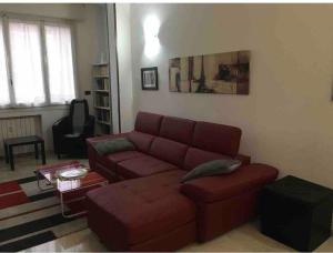 Splendido appartamento in zona fiera a bologna في بولونيا: غرفة معيشة مع أريكة حمراء وطاولة