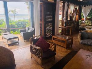a living room filled with furniture and a large window at HomeOnTheNile in Jinja