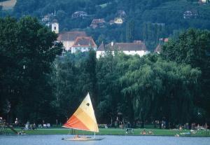 a sailboat in the water with people on a park at Biohof Laibacher in Stubenberg