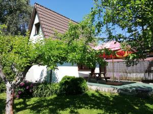 a house with a garden and an umbrella at Chaty v Českém ráji u Prachovských skal Chata pro 4 a pro až 7 osob - v soukromí in Holín