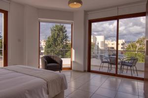 - une chambre avec un lit et un balcon avec une table et des chaises dans l'établissement Phaedrus Living: City Flat Palas 102, à Paphos
