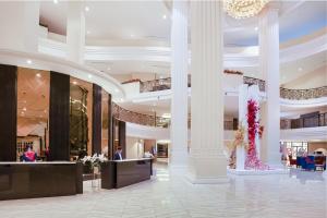 a lobby of a hotel with columns and a chandelier at Grand Palazzo Hotel - SHA Extra Plus in Pattaya Central