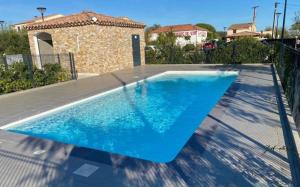 a blue swimming pool in a backyard with a house at sylvie in Le Plan-de-la-Tour