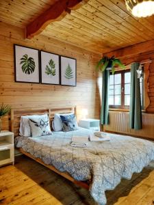 a bedroom with a bed in a wooden room at Pokoje i Domki Na Szlaku in Polanica-Zdrój