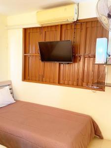 Habitación con cama y TV de pantalla plana en la pared. en Ban Lake View en Pak Chong