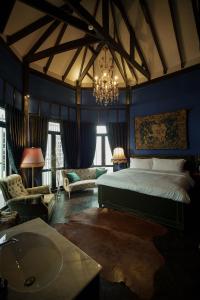 a bedroom with a bed and a chandelier at Baan Tuk Din Hotel in Bangkok +77 photos