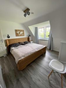 sypialnia z łóżkiem, krzesłem i oknem w obiekcie FeWo Ostsee Ahoi w mieście Timmendorfer Strand