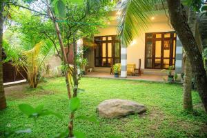 una casa con un giardino con una roccia davanti di Sunliya Resort a Tangalle