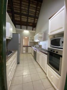 a large kitchen with white cabinets and appliances at La plage in Centre de Flacq