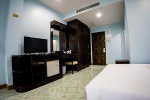 a bedroom with a bed and a tv and a mirror at Riviera Patong in Patong Beach