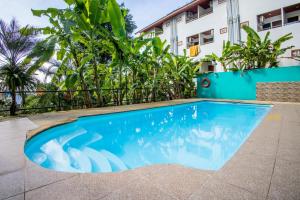巴東海灘的住宿－Riviera Patong，大楼前的蓝色游泳池