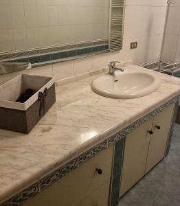 ein Badezimmer mit einem Waschbecken und einer Theke mit einem Waschbecken in der Unterkunft B&b Binario38 in Benevento