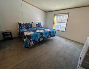 1 dormitorio con 1 cama con edredón azul y ventana en 192LHr, en Bethlehem