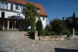 ein Haus mit einem Baum vor einer steinernen Einfahrt in der Unterkunft Pension Will in Kusterdingen