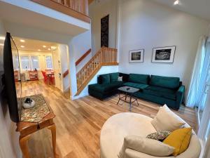 sala de estar con sofá verde y escalera en R18 Affordable Ski-in Ski-out Bretton Woods Townhome mountain views, en Carroll