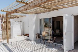 Un patio con una mesa y sillas en un porche. en Moorings 2, en Paternoster