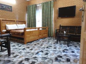 a living room with a bed and a flat screen tv at Kashmir lodge in Muzaffarabad