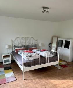 1 dormitorio con cama blanca y almohadas rojas en Ferienwohnung Nordlicht en Rostock