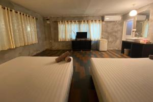 1 dormitorio con 2 camas y baño con lavamanos en Crescent Bay Resort en Ko Samed