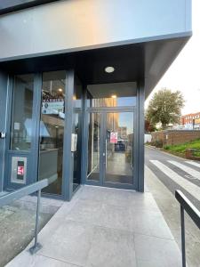 an office building with glass doors on a street at One Bedroom Serviced Apartments in Harrow in Pinner