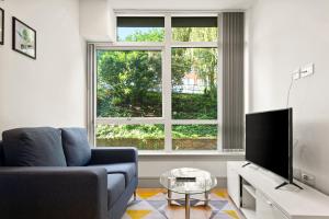a living room with a couch and a large window at One Bedroom Serviced Apartments in Harrow in Pinner
