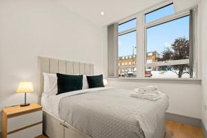 a bedroom with a large bed and a window at One Bedroom Serviced Apartments in Harrow in Pinner