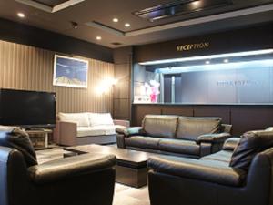 un soggiorno con divani e TV a schermo piatto di HOTEL LiVEMAX BUDGET Hiratsuka Ekimae a Hiratsuka