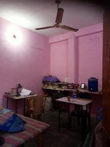 Cette chambre est dotée de murs roses, de tables et de chaises. dans l'établissement Laxmi boys Hostel By WB Inn, à Kanpur