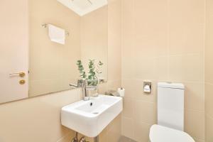 a bathroom with a sink and a toilet and a mirror at Hotel Zorna Plava Laguna in Poreč