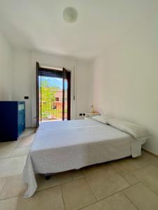 - une chambre blanche avec un grand lit et une fenêtre dans l'établissement Jennas- Blue Apartment, à Àrbatax