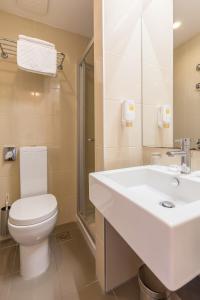 a bathroom with a white sink and a toilet at Hotel Zorna Plava Laguna in Poreč