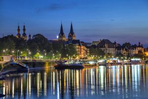Una ciudad de noche con barcos en el agua en Ferienwohnung Koblenz, en Coblenza