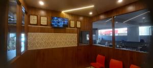 a waiting room with red chairs and a television at CTC GARDENIA RESIDENCY in Bangalore