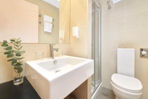 a bathroom with a white sink and a toilet at Hotel Zorna Plava Laguna in Poreč