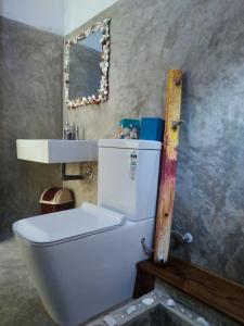 uma casa de banho com um WC, um lavatório e um espelho. em Barefoot Inn Kandy em Kandy