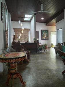 uma sala de estar com uma mesa e um piano em Barefoot Inn Kandy em Kandy