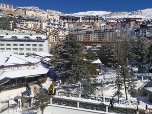 Blick auf eine Stadt mit schneebedeckten Bäumen und Gebäuden in der Unterkunft Bed and Snow Family Apartments in Sierra Nevada