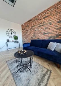sala de estar con sofá azul y pared de ladrillo en Sun and holidays apartament Władysława IV en Gdynia