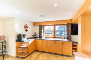 una cocina con armarios de madera y una gran ventana en Finkenhof, en Schluchsee