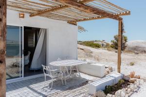 a patio with a table and chairs on the beach at Moorings 3 in Paternoster