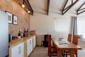 a kitchen with a table and a brick wall at Moorings 3 in Paternoster