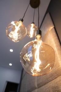 a group of glass bulbs hanging from a ceiling at THE NEWSHA SIGNATURE HOME in Mülheim an der Ruhr